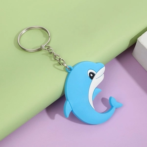 Close-up of a blue cartoon dolphin keychain with white belly and silver metal ring