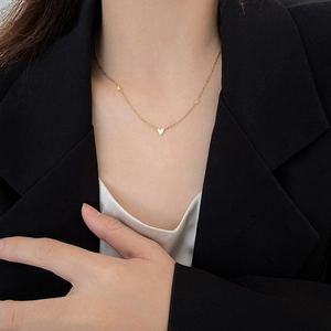 Minimalist 18K gold heart pendant necklace for women worn on neck with black blazer