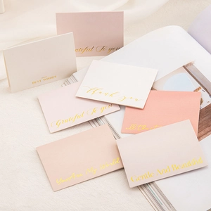 Detail of elegant gold-stamped greeting cards on soft fabric for gift occasions