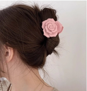 Détail d'une pince à cheveux rose en forme de rose 3D pour une coiffure élégante