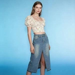 Close-up of denim skirt high-waisted design with front slit and raw hemline detail