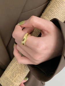 Detailed view of an irregular wave pattern gold ring set with sparkling pave diamonds