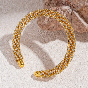 Gros plan du bracelet doré en strass avec design géométrique sur une base en pierre