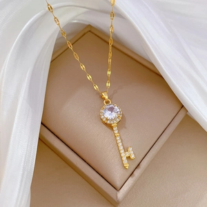 Elegant gold titanium necklace with a sparkling zircon encrusted key pendant on silk