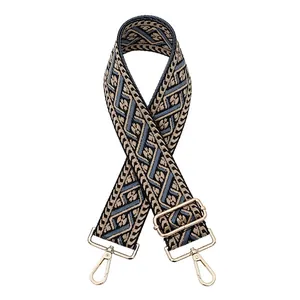 Detail of jacquard ethnic bag strap with geometric weave and golden metal hardware hooks