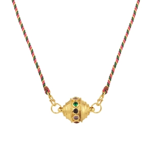 Detail of a golden globe pendant with colorful cubic zirconia on a braided woven cord