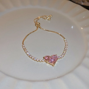 Close-up of pink heart cat-eye stone bracelet with gold plating and white zircon inlay