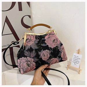 Detail of vintage floral qipao bag featuring pink peony embroidery and wooden handle