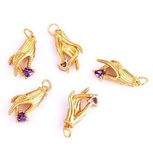 Macro detail of hand-shaped copper charms featuring purple heart-shaped gemstones