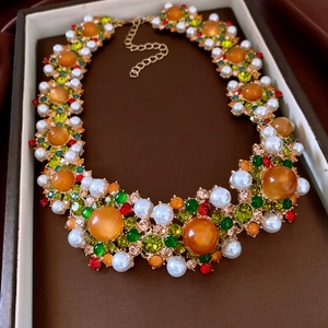 Detail eines Vintage-Schmucksets mit orangen Steinen und Perlen in einer Box