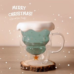 Christmas tree double-walled glass cup with white lid and wooden coaster in festive setting