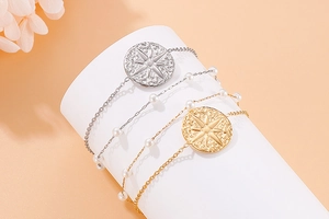 Detail of double-layer stainless steel bracelet with star compass and pearl beads