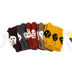 Detailed view of knitted skull patterned leg warmers in various colors including red and grey