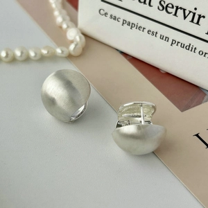 S925 sterling silver brushed hemisphere earrings on white surface with pearl necklace