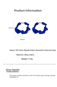 Macro view of blue fabric texture and 6.5cm geometric hoop on silver needle earring