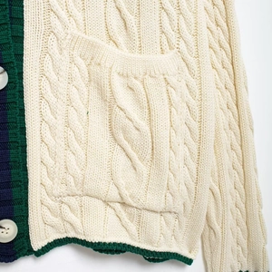 Women's cable knit V-neck cardigan sweater with contrast striped trim and pocket detail
