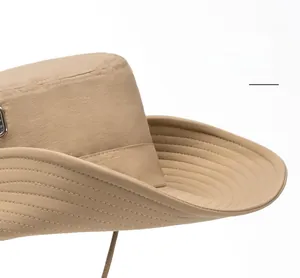 Detailed macro view of khaki wide-brim sun hat with reinforced stitching and metal logo
