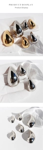 Macro shot of mirror-finish teardrop earrings in gold and silver, showing various sizes