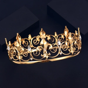 Elegant gold round crown with fleur-de-lis pattern and crystals on dark reflective surface