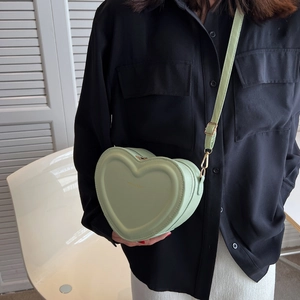 Dettaglio della borsa a tracolla a forma di cuore verde menta con scritta Fashion