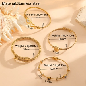 Bracelet jonc en acier inoxydable doré avec cœur serti de strass sur fond beige