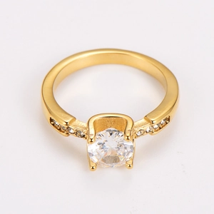 Detailed macro view of four-prong gold plated ring featuring round zircon center stone