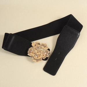 Détail de la boucle florale dorée en relief sur une large ceinture élastique noire