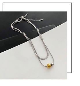 Detail of double-layer silver snake chain with gold and silver bead accents