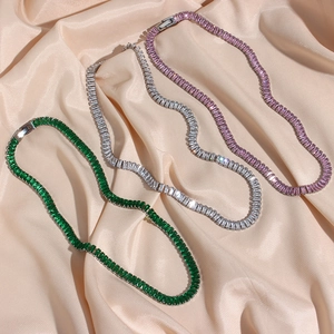 Detailed view of colorful zircon tennis necklaces on elegant silk fabric background