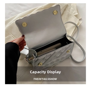 Detail view of the silver quilted crossbody bag interior holding a large smartphone