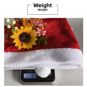 Close-up showing the precise 57g weight of the plush red sunflower Christmas hat
