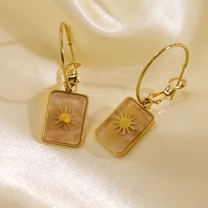 Elegant gold earrings with natural stone shell inlays and starburst patterns on satin