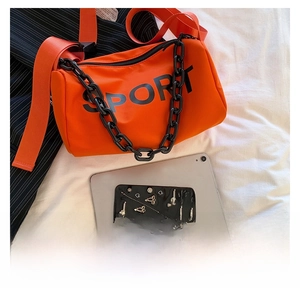 Détail du sac en nylon orange avec texte SPORT noir et grosse bandoulière chaîne