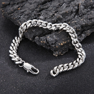 Macro shot of silver titanium steel Cuban chain bracelet on industrial stone background