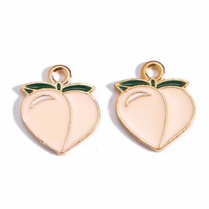 Detail showing two gold peach alloy charms with pink enamel and green leaf accents