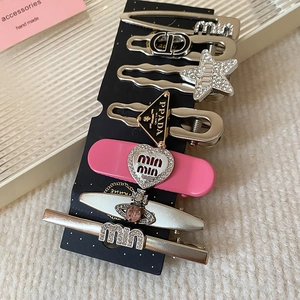 Detailed set of silver hair clips with pink rhinestones, heart and star designs on black card