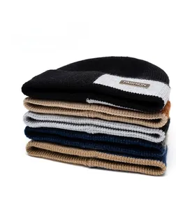 Detail of chunky knit winter beanies with leather logo patch and thick rib texture