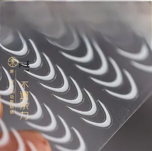 Macro detail of white 5D embossed nail stickers with matte 3D texture on clear PET sheet