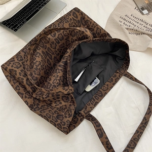 Detail of leopard print tote bag interior with a functional zipper pocket and black lining