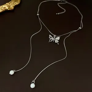 Elegante silberne Schmetterlingskette mit Zirkonia-Quasten auf Premium-Lederhintergrund