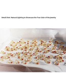 Detail shot of vintage-style red enamel rose earrings with gold metal and green leaves