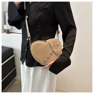 Vue détaillée du sac bandoulière en forme de cœur avec rivets et cuir synthétique kaki lisse