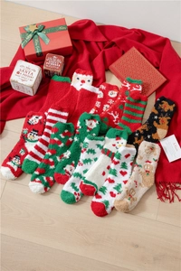 Detail of plush Christmas coral fleece socks with festive holiday patterns and warm textures