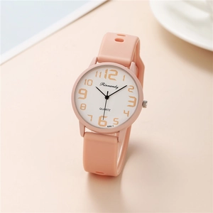 Close-up of pink silicone watch strap and round quartz dial with gold numerals
