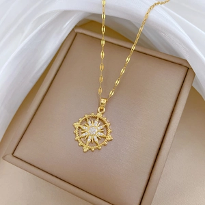 Luxurious gold starburst pendant necklace with zircon stones on beige velvet display