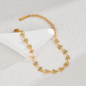 Gold stainless steel flower necklace with blue enamel pendants on white surface