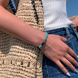 Minimalist geometric beaded bracelet with turquoise and onyx beads on model wrist