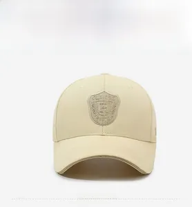Detailed close-up of shield embroidery on beige cotton baseball cap with classic letters