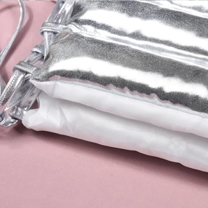 Macro shot of silver metallic quilted fabric detailing and white lining on the skirt