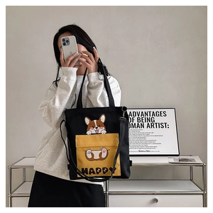 Detail of black canvas tote bag with yellow Corgi pocket and Happy text print